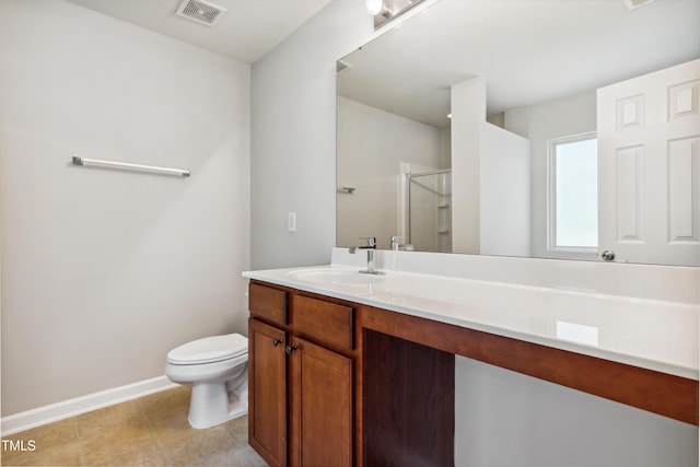 bathroom featuring a shower stall, vanity, baseboards, toilet, and tile patterned flooring