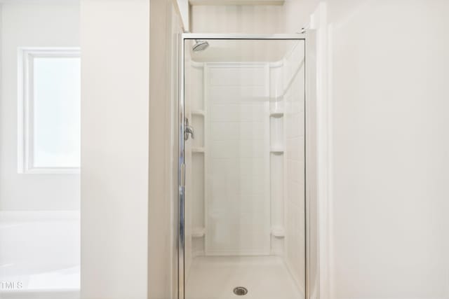 bathroom with a shower stall and a bath
