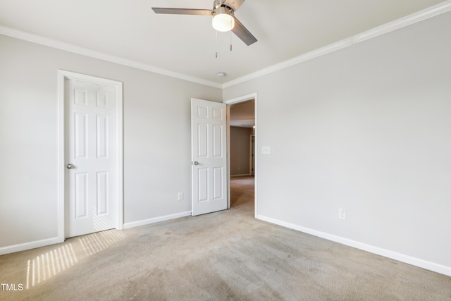 unfurnished bedroom featuring carpet floors, ornamental molding, baseboards, and ceiling fan