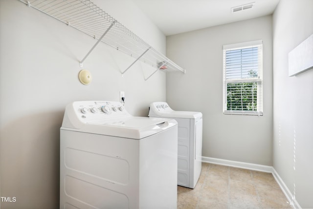 clothes washing area featuring washer and clothes dryer and baseboards