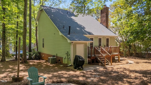 back of property featuring central AC, roof with shingles, a chimney, and a deck