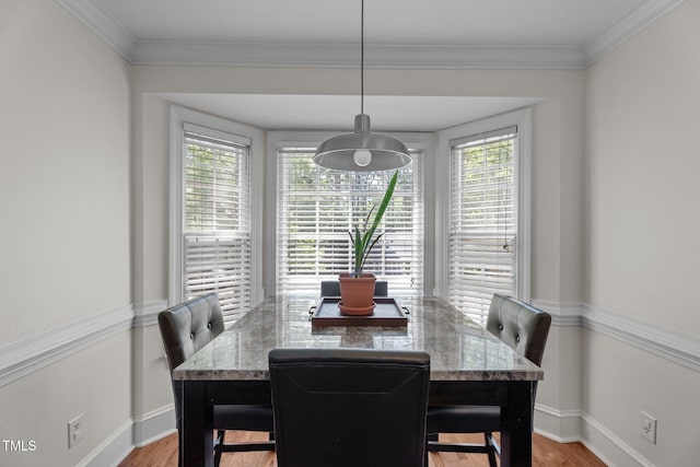 dining area with baseboards, light wood-style floors, and ornamental molding