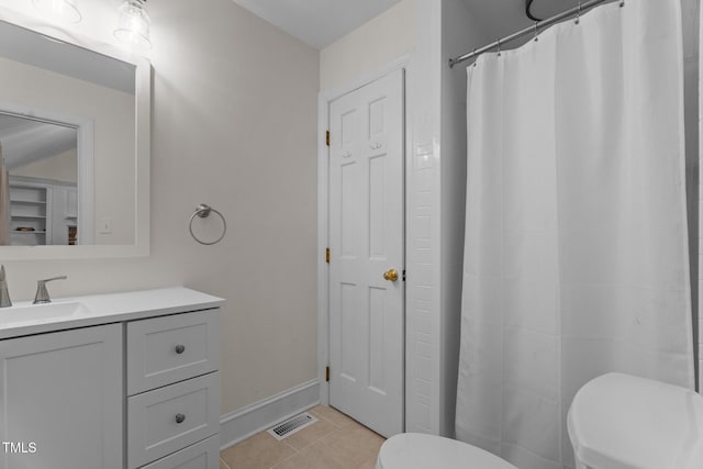 bathroom featuring toilet, tile patterned floors, vanity, baseboards, and a shower with shower curtain