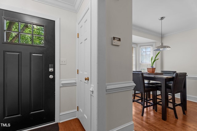 entrance foyer featuring ornamental molding, wood finished floors, and baseboards