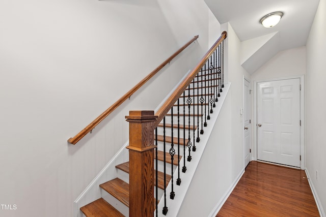 staircase featuring baseboards and wood finished floors