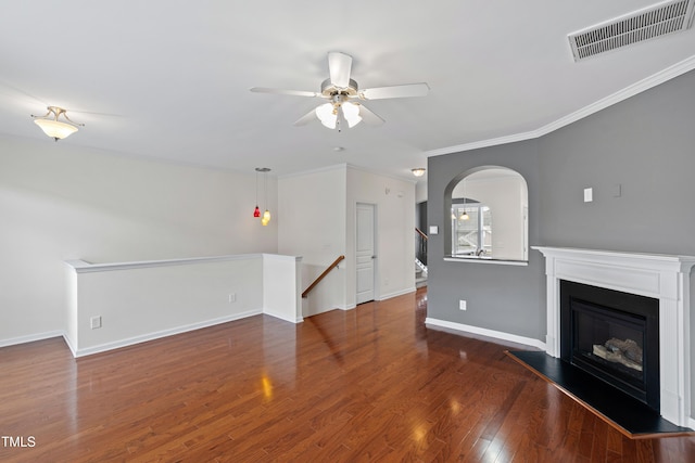 unfurnished living room with a ceiling fan, crown molding, wood finished floors, a glass covered fireplace, and baseboards