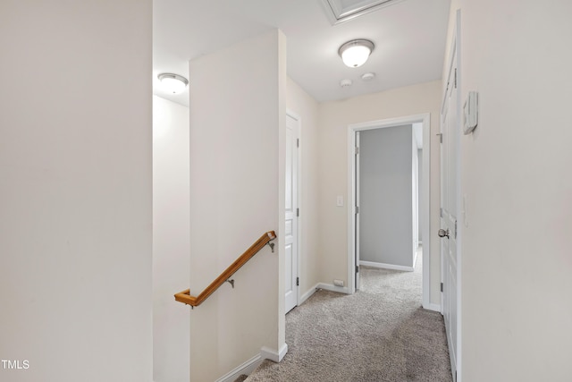 hallway featuring an upstairs landing, light colored carpet, and baseboards