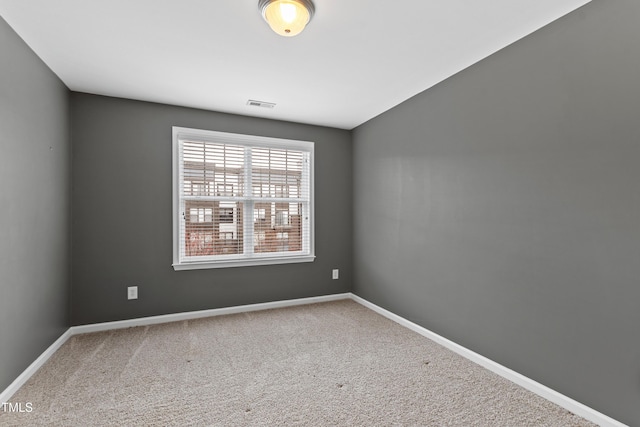 carpeted spare room featuring baseboards
