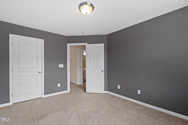 unfurnished bedroom featuring carpet floors and baseboards