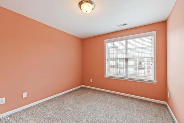 carpeted empty room featuring baseboards