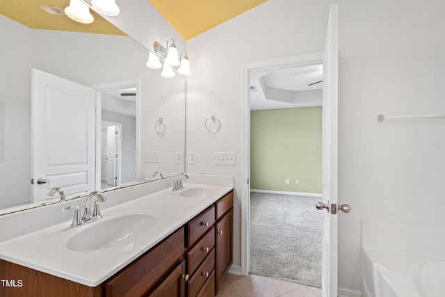 bathroom with double vanity, a bath, tile patterned flooring, and baseboards