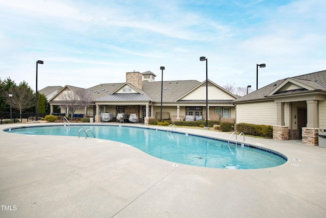 community pool featuring a patio area and fence