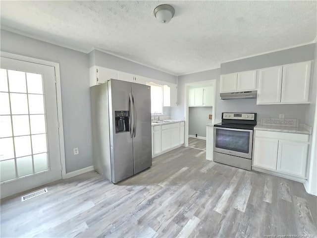 6841 Radial Dr, Fayetteville, NC 28311 - kitchen with appliances with stainless steel finishes, under cabinet range hood, a sink, a textured ceiling, and white cabinetry