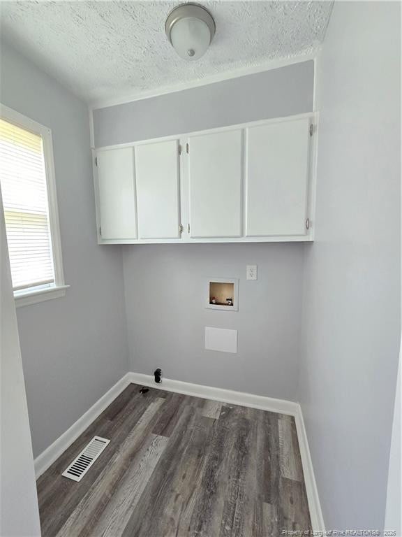 6841 Radial Dr, Fayetteville, NC 28311 - clothes washing area with cabinet space, hookup for a washing machine, dark wood finished floors, a textured ceiling, and baseboards