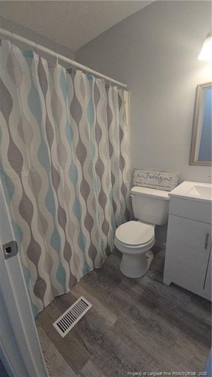 6841 Radial Dr, Fayetteville, NC 28311 - bathroom with wood finished floors, toilet, and vanity