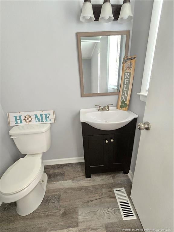 6841 Radial Dr, Fayetteville, NC 28311 - half bath with wood finished floors, vanity, baseboards, and toilet