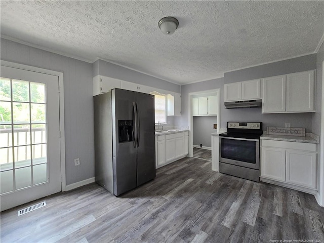 6841 Radial Dr, Fayetteville, NC 28311 - kitchen with appliances with stainless steel finishes, under cabinet range hood, a sink, white cabinets, and healthy amount of natural light