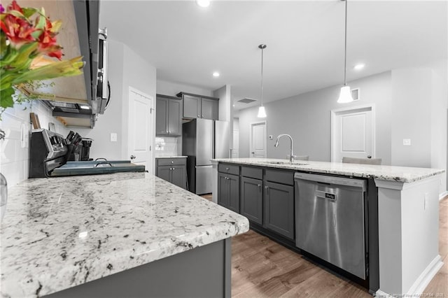 308 Laurel Lake Rd, Salemburg, NC 28385 - kitchen with stainless steel appliances, a sink, gray cabinets, dark wood-style flooring, and light stone countertops