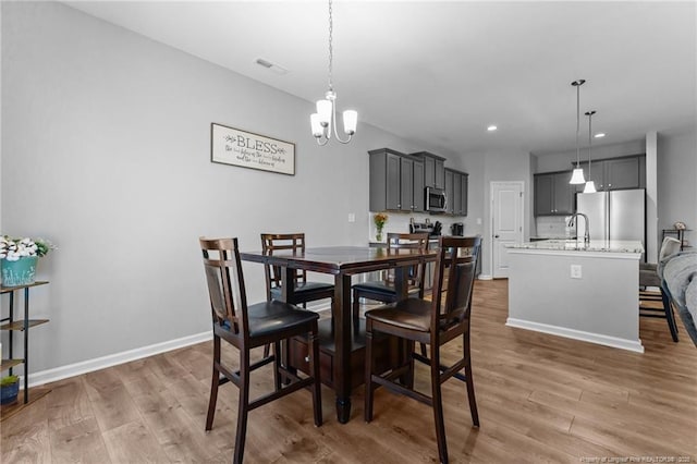 308 Laurel Lake Rd, Salemburg, NC 28385 - dining room featuring light wood-type flooring, a chandelier, baseboards, and recessed lighting