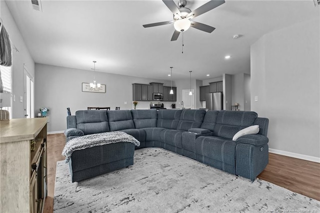 308 Laurel Lake Rd, Salemburg, NC 28385 - living area featuring wood finished floors, a ceiling fan, a chandelier, baseboards, and recessed lighting