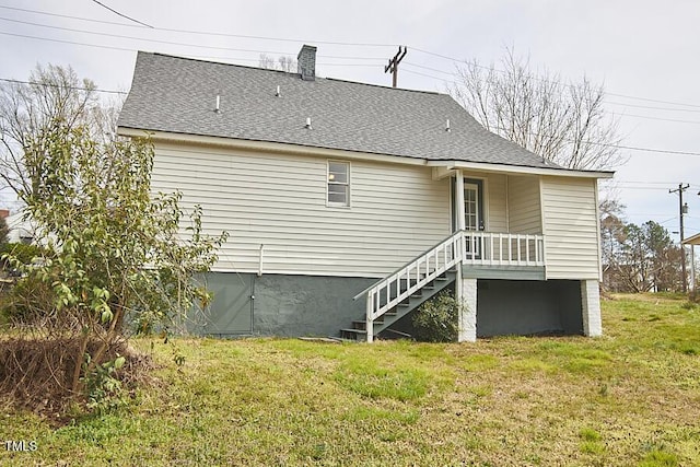 back of house with a yard, stairs, and roof with shingles