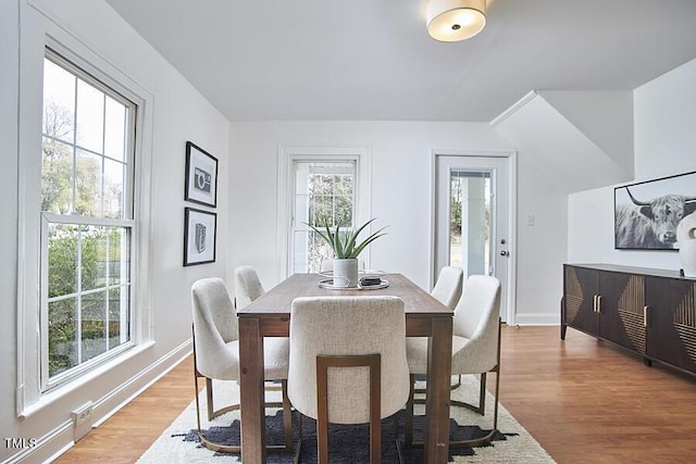 dining area featuring light wood-style floors and baseboards