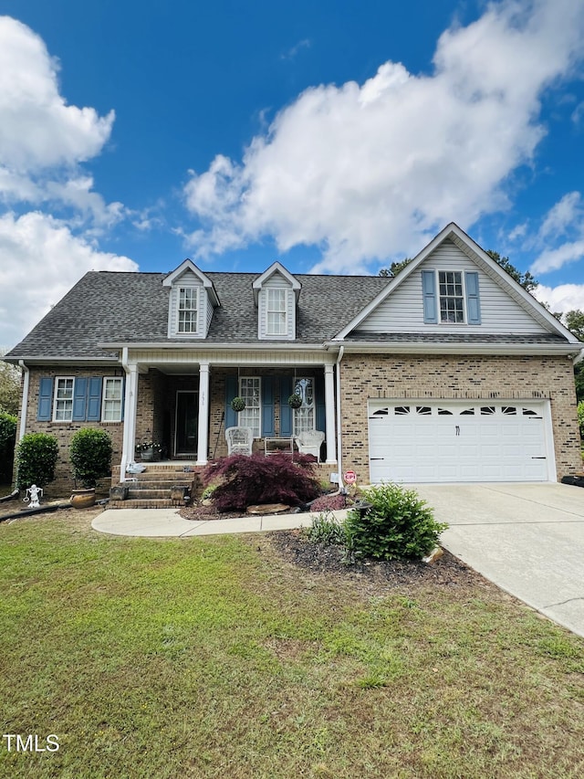 view of front facade with concrete driveway, a porch, a front lawn, and brick siding