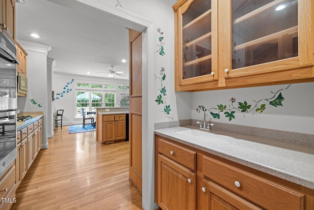 bar area featuring light wood-style flooring, a sink, a ceiling fan, recessed lighting, and appliances with stainless steel finishes