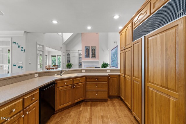 kitchen with dishwasher, a sink, built in refrigerator, light countertops, and recessed lighting