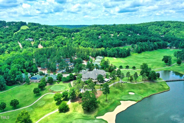 aerial overview of property's location featuring a large body of water, a local golf course, and a heavily wooded area