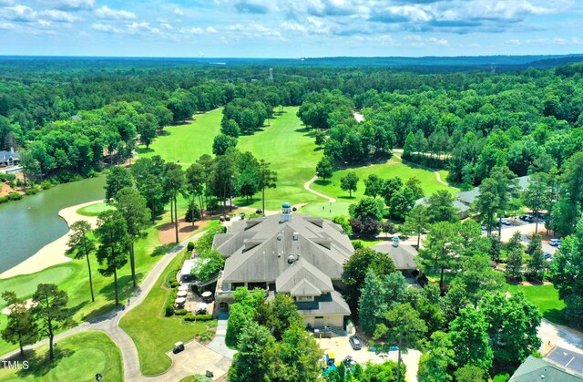 aerial view of a golf course, a forest, and a large body of water