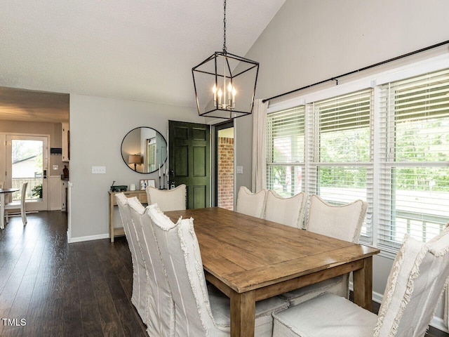 dining room featuring a chandelier, dark wood-type flooring, baseboards, and lofted ceiling