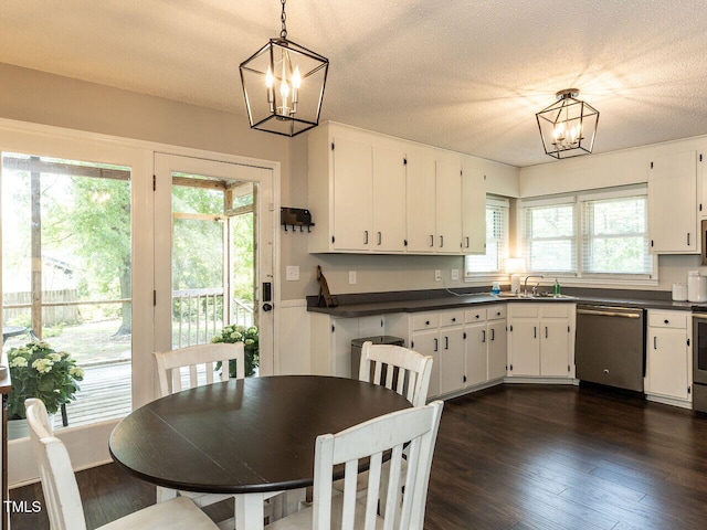 dining area featuring a chandelier, dark wood-style flooring, and a textured ceiling