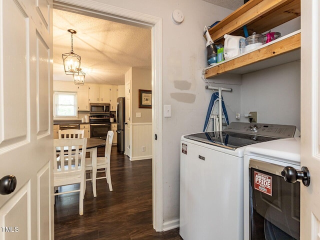 laundry room featuring washer and clothes dryer, a textured ceiling, and dark wood finished floors