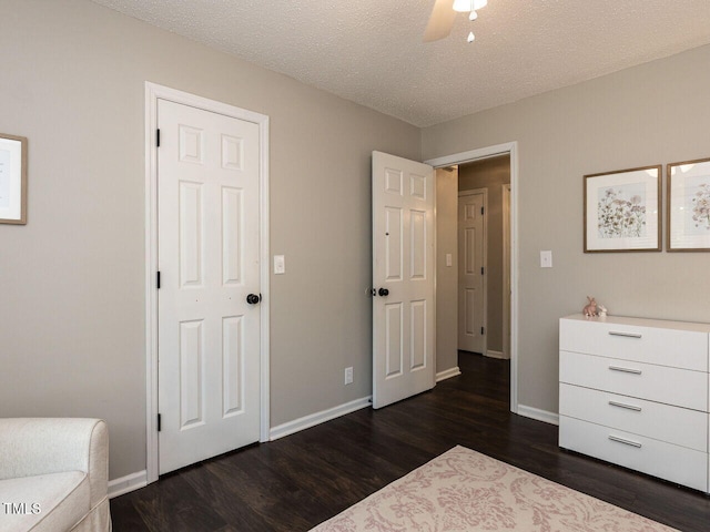 bedroom featuring dark wood-style flooring, baseboards, a textured ceiling, and ceiling fan