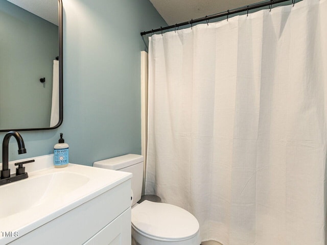bathroom featuring toilet, vanity, and a textured ceiling