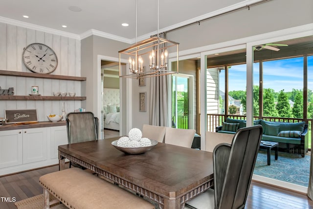 dining space featuring crown molding, dark wood-style flooring, a chandelier, recessed lighting, and ceiling fan