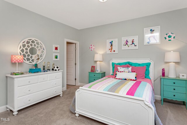 bedroom with light colored carpet and baseboards