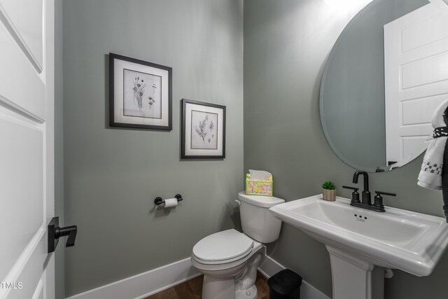 318 Ivy Ridge Rd, Chapel Hill, NC 27516 - half bathroom with baseboards, toilet, wood finished floors, and a sink