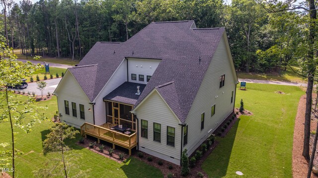 318 Ivy Ridge Rd, Chapel Hill, NC 27516 - rear view of house featuring roof with shingles, a deck, a lawn, and a view of trees