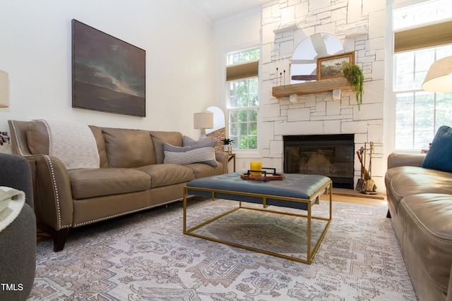 living area featuring a stone fireplace and ornamental molding