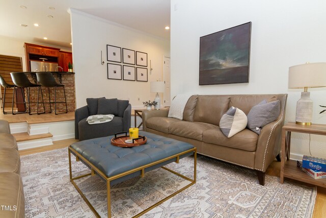 living room featuring light wood-style flooring, recessed lighting, and crown molding