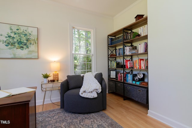 living area featuring wood finished floors, crown molding, baseboards, and an office area