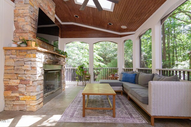 sunroom / solarium featuring healthy amount of natural light, a skylight, and vaulted ceiling