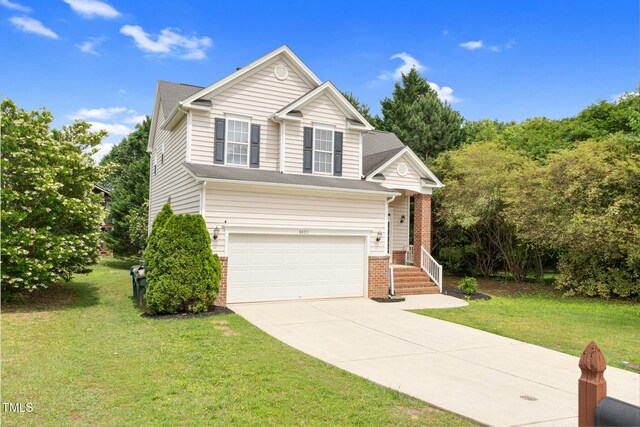 8820 Waynick Dr, Raleigh, NC 27617 - traditional-style house with concrete driveway, brick siding, an attached garage, and a front yard
