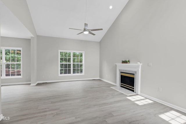 8820 Waynick Dr, Raleigh, NC 27617 - unfurnished living room featuring a ceiling fan, healthy amount of natural light, a premium fireplace, wood finished floors, and high vaulted ceiling