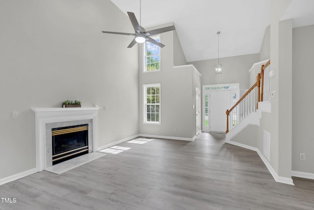 8820 Waynick Dr, Raleigh, NC 27617 - foyer entrance featuring high vaulted ceiling, wood finished floors, stairs, ceiling fan, and a high end fireplace