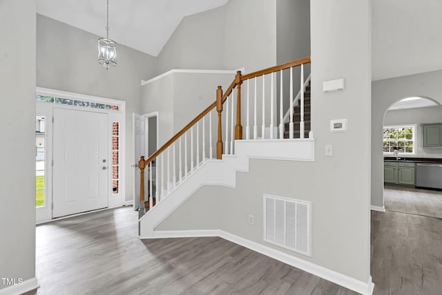 8820 Waynick Dr, Raleigh, NC 27617 - entrance foyer with high vaulted ceiling, wood finished floors, arched walkways, stairway, and baseboards