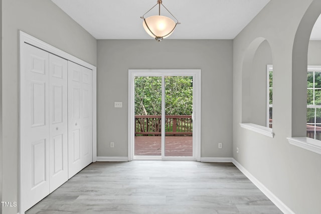 8820 Waynick Dr, Raleigh, NC 27617 - unfurnished dining area featuring wood finished floors, arched walkways, and baseboards