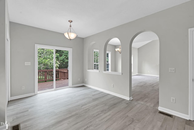 8820 Waynick Dr, Raleigh, NC 27617 - unfurnished room with light wood-style floors, baseboards, and arched walkways